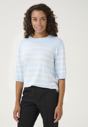 Helles blaues Strickpullover mit kurzen Ärmeln, ausgestattet mit horizontalen gelben Streifen und einem Rundhalsausschnitt. Kombiniert mit schwarzen Hosen.