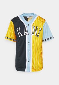 Vícebarevný dres s černými, žlutými a světle modrými panely, výrazným nápisem "K.A.N.I", zapínáním na knoflíky a pruhovanými detaily na rukávech.