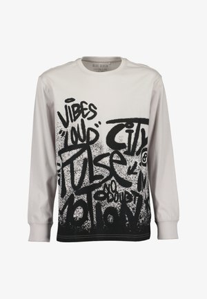 Biała koszula z długim rękawem z czarnym tekstem w stylu graffiti, zawierającym napisy "Vibes", "Loud" i "Pulse" pokrywającym przód.