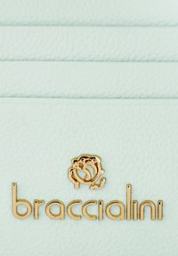 Lichtblauwe leren portemonnee met een gladde textuur, goudkleurig logo met bloemontwerp en reliëf merknaam "braccialini."