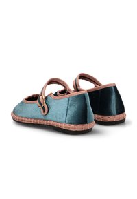 Zapatos de terciopelo en verde azulado con una correa y detalles en rosa, que cuentan con una suela cosida y un diseño de punta redondeada. La vista trasera resalta la textura suave.