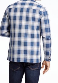 Sininen ja valkoinen ruudullinen pitkähiha-paita, joka on valmistettu kankaan teksturoidulla kuviolla. Siinä on napilliset hihansuut ja suora helma.