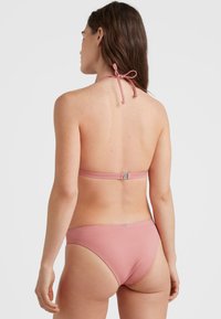 Dvivietis bikinis švelnios rožinės spalvos. Kaklo juostos su surišimu ir metaliniu užsegimu gale. Lygus, tamprus audinys su klasikiniu kirpimu.