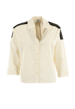 Crèmekleurig overhemd met driekwart mouwen, voorzien van zwarte schouderaccenten en een losse pasvorm. Gemaakt van lichte stof.