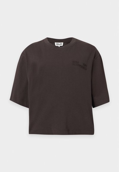 T-shirt court marron foncé à manches courtes avec texte de logo embossé sur la partie supérieure gauche de la poitrine.