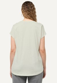 Camiseta de manga corta verde claro con escote redondo y botones en los hombros, fabricada en suave tejido de algodón, con un corte relajado.