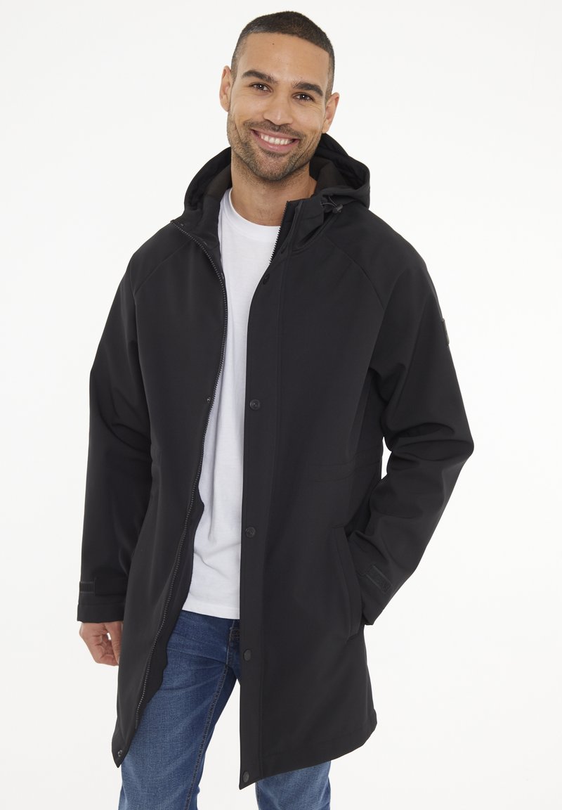 Chaqueta negra impermeable con capucha, cremallera y cierre de botones a presión. Presenta una textura suave, mangas largas y bolsillos laterales. Diseño casual.