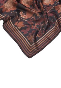 Paño de seda con un patrón floral en tonos cálidos de óxido y beige, sobre un fondo oscuro con un borde a rayas.