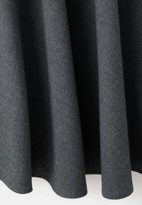 Tissu gris foncé drapé en plis doux avec une texture lisse, suspendu verticalement sur un fond clair.
