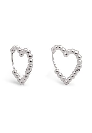 Boucles d'oreilles créoles en argent en forme de cœur, composées de petites perles rondes avec des fermoirs à charnière sur fond blanc.