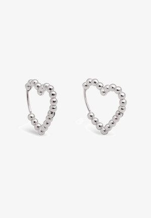 Boucles d'oreilles créoles en argent en forme de cœur, composées de petites perles rondes avec des fermoirs à charnière sur fond blanc.