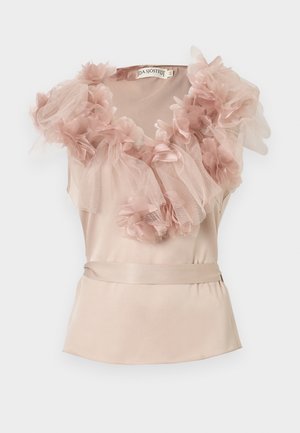 Bezrekawowa blada różowa satynowa bluzka z pasującym paskiem, zdobiona warstwowym tiulem i materiałowymi kwiatami wokół dekoltu i ramion.