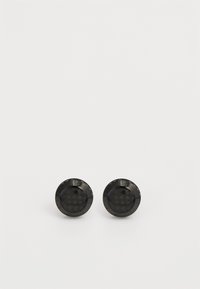 Boucles d'oreilles rondes noires avec une surface texturée et une marque gravée. Fini lisse avec un aspect brillant et un petit trou central.