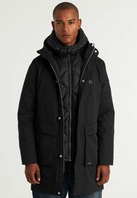 Juodas parka tipo džemperis su užtrauktuku ir mygtukų uždarymu, didelėmis kišenėmis, quilted vidiniu sluoksniu ir su raišteliu reguliuojama kapuce. Tekstūruota medžiaga, laisvas siluetas.