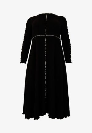 Schwarzes langärmliges Kleid mit ausgestellt Rock. Es zeichnet sich durch einen strukturierten Stoff, gewellte Kanten und kontrastierende weiße Nähte entlang der Nähte aus.