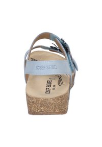 Světle modré sandály s korkovou podrážkou, nastavitelné popruhy a květinovými akcenty. Pohodlný design s měkkou stélkou a embosovanou značkou.