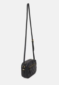 Borsa a tracolla nera trapuntata con forma rettangolare, tracolla regolabile, due tasche con zip e dettagli in hardware color oro. Texture liscia.