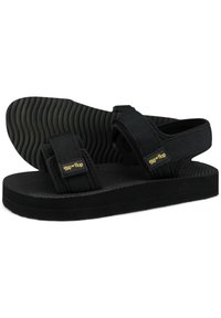 Black sandals with adjustable fabric straps, textured rubber sole, and a cushioned footbed. Simple design with logo detail on straps.