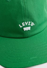 Zöld, pamutból készült baseball sapka, hímzett fehér "Levi's" logóval és kontrasztos varrással a különböző részeken.