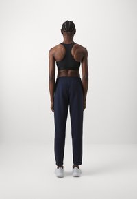 adidas Sportswear ESSENTIALS SMALL LOGO FEEL COZY OPEN HEM PANT - Calças de fato de treino - legend ink