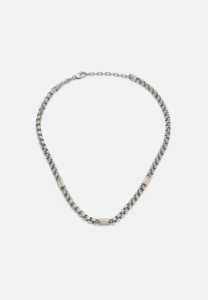 Collier en chaîne argentée avec des accents dorés intercalés, présentant un design à maillons arrondis et un fermoir texturé pour un maintien sécurisé.