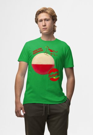 Zelené bavlněné tričko s grafikou krávy a sýru Babybel. Text zní "PŘIPOJTE SE K DOBROTĚ" v červené barvě. Krátké rukávy a volný střih.