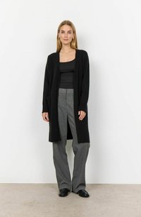 Black open-front cardigan made of textured fabric, featuring long sleeves, side pockets, and paired with grey pinstriped trousers.