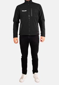 Veste zippée noire, avec un col montant, des poches latérales, une poche horizontale sur la poitrine et un logo blanc sur l'épaule gauche. Tissu doux.