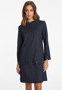 Dunkelblaues Jeanskleid mit vertikalen Streifen, rundem Halsausschnitt, langen Ärmeln und zwei vorderen Taschen mit Knopfakzenten.