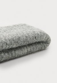 Gray woolen fabric folded, featuring a soft, textured surface with visible fibers, showcasing a light to dark gradient in color.