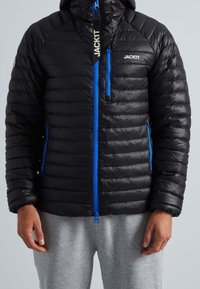 Veste matelassée noire avec fermeture éclair bleue et accents bleus, dotée d'une capuche, de coutures horizontales et de poches latérales. Le matériau semble brillant et léger.