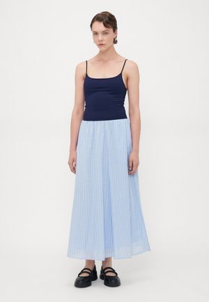Marineblå tank top kombinert med et lys blått, gulvlengde skjørt med vertikale striper og svarte, teksturerte slip-on sko.