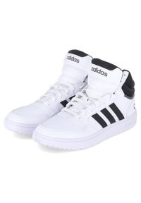 Hvide høj-topsneaks med sorte detaljer, der har tre striber, snørebåndsdesign, polstret krave og struktureret tunge. Brandlogo synligt.