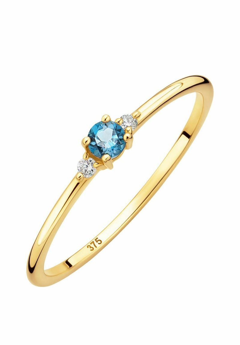 Anello in oro con un centrale pietra rotonda di acquamarina, affiancata da due piccole pietre rotonde trasparenti, con una fascia liscia e lucida.