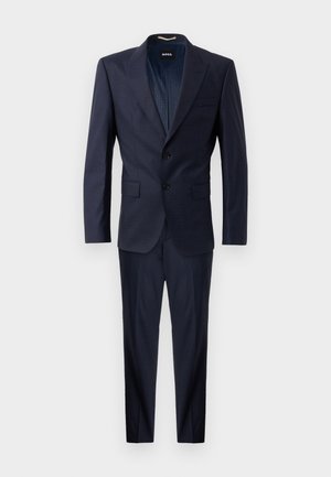 Námornícky modrý oblek z textúrovanej látky, so zapínaním na dva gombíky, klopovými goliermi a nohavicami rovného strihu. Podšívka s jemným vzorom.
