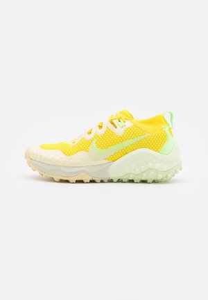 Żółty i jasnozielony but do biegania Nike z cholewką z siateczki, teksturowaną podeszwą i sznurowanym designem, pokazany z boku na białym tle.