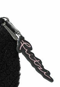 Borsa nera con texture, dotata di cerniera e etichetta in pelle con scritta rosa. La cerniera ha componenti metallici e funzionali.