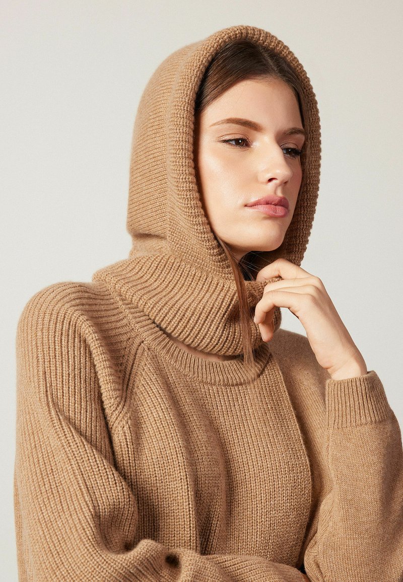 Kamelhaarfarbener Strickpullover mit hohem, geripptem Kragen und Kapuze. Verfügt über einen strukturierten Stoff und eine lockere Passform mit gerippten Bündchen.