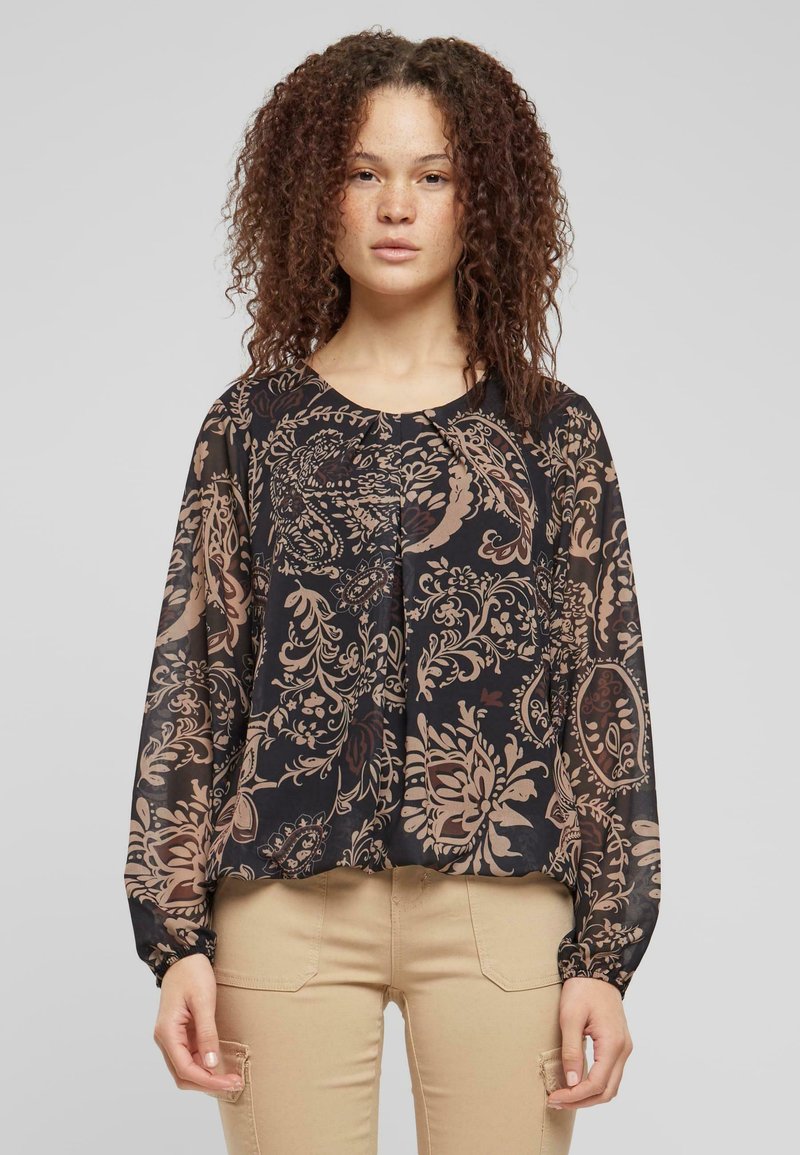 Blusa nera e trasparente con intricate fantasie floreali marroni, maniche lunghe e scollatura rotonda. Presenta un dettaglio di tessuto arricciato nella parte anteriore.