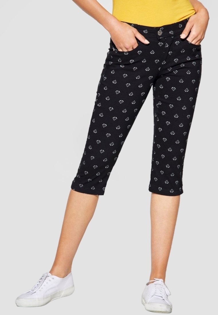 Svarta capribyxor med vita geometriska mönster, utrustade med knappstängning och framfickor, tillverkade av ett mjukt och flexibel tyg.