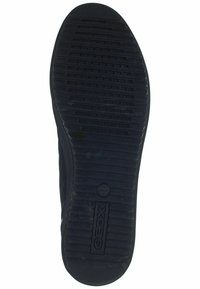 Semelle de chaussure en caoutchouc noir avec rainures texturées, détail de logo circulaire, et trous de drainage pour la respirabilité. Design large et plat pour la stabilité.