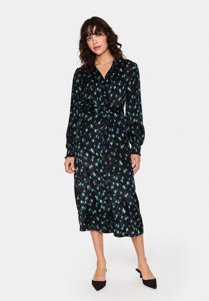 Zwarte jurk met groen en blauw bloemenpatroon, lange mouwen, knoopsluiting aan de voorkant, tailleband en halflange zoom, gemaakt van een zachte stof.