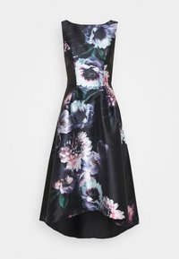 Vestido negro sin mangas con bajo asimétrico y gran estampado floral en púrpura, blanco y rosa sobre tela lisa.