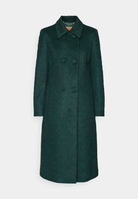 Long manteau en laine vert foncé à double boutonnage avec large col et boutons cachés, présenté sur un fond clair uni.