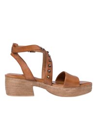 Bruna läderplattformssandaler med en bred framrem och en vristrem dekorerad med metalliska nitar. Kraftig, strukturerad klack.