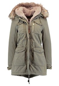 Parka d'hiver verte avec capuche doublée de fourrure, plusieurs poches avant, fermetures éclair et boutons, et doublure intérieure douce en polaire beige.