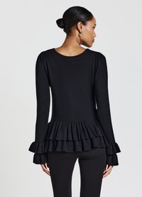 Maglietta nera a maniche lunghe con scollo rotondo e orlo a balze testo. Presenta maniche aderenti e un tessuto morbido con una leggera lucentezza.