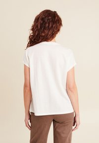 Witte korte mouwen t-shirt van zachte stof, met een ronde halslijn en een ontspannen pasvorm. Smalle textuur zonder zichtbare patronen.
