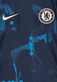 Maglietta da calcio blu scuro con motivi grafici blu, logo Nike in oro e distintivo circolare del Chelsea FC con emblema di leone.