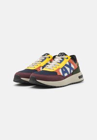 Flerfargede sneakers med overdel i mesh og semsket skinn, gummisåle, fremtredende hvit logo og kontrasterende gule snørebånd.